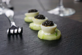 Cucumber rounds with cream cheese, qual eggs and caviar